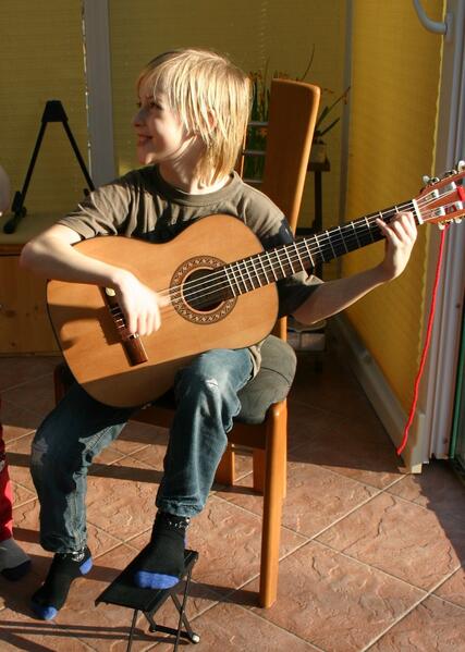 Kind beim Kindergitarrenkurs